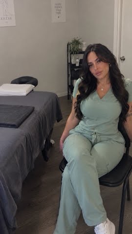 Lilly seated beside a massage table